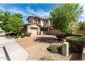 Beautiful home features a well-maintained yard with stone accents and brick driveway at 14727 W Pasadena Ave, Litchfield Park, AZ 85340