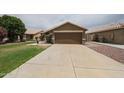 Driveway view of a two-car garage of a well-maintained, single-story home at 16036 W Desert Bloom St, Goodyear, AZ 85338