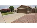 Single-story home featuring a long driveaway leading to a two-car garage at 16036 W Desert Bloom St, Goodyear, AZ 85338