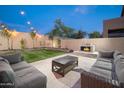 Relaxing backyard with a stone fireplace and plush outdoor seating, perfect for entertaining at 22259 N 102Nd Ln, Peoria, AZ 85383