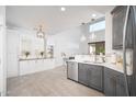 Bright, neutral kitchen featuring two-tone cabinets, stainless appliances, and stylish pendant lighting at 22259 N 102Nd Ln, Peoria, AZ 85383