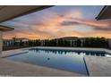 Backyard pool with travertine tile and mountain views at sunset at 24138 S 220Th St, Queen Creek, AZ 85142