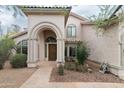 Inviting front entrance with an arched doorway, tiled roof, and desert-style landscaping at 2709 E Vista Dr, Phoenix, AZ 85032