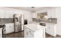 Modern kitchen with white cabinetry, stainless steel appliances, marble countertops, and wood floors at 2710 S Shelby --, Mesa, AZ 85209