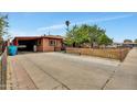 Home featuring a covered parking area and a fenced front yard, set under a clear blue sky at 2907 W Townley Ave, Phoenix, AZ 85051