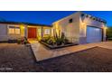 Home featuring desert landscaping, warm exterior lighting, and a welcoming front entrance at 3133 E Claire Dr, Phoenix, AZ 85032