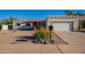 Home with desert landscaping and a garage, all illuminated by the sun, showcases the outdoor charm at 3133 E Claire Dr, Phoenix, AZ 85032