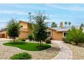 Beautifully landscaped front yard with lush green grass, mature trees, and a brick walkway at 3358 W Sandra Ter, Phoenix, AZ 85053