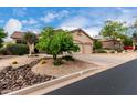 Single-story home with a three-car garage, desert landscaping, and a view from the side of the home at 3460 N Stone Gully St, Mesa, AZ 85207