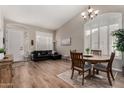 Living room and dining area featuring wood floors, neutral walls, and a vaulted ceiling at 3460 N Stone Gully St, Mesa, AZ 85207