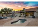Resort-style backyard with a sparkling pool, spa, covered patio, and lush desert landscaping at 4329 W Electra Ln, Glendale, AZ 85310