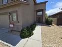 Exterior side view of a home showcasing desert landscaping and arched entryway at 43455 W Chisholm Dr, Maricopa, AZ 85138