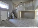 Spacious foyer featuring a grand staircase, tile floors, and high ceilings at 43455 W Chisholm Dr, Maricopa, AZ 85138