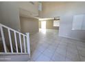 Open-concept living room with tile floors and abundant natural light from the sliding glass door at 43455 W Chisholm Dr, Maricopa, AZ 85138