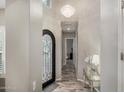 Elegant foyer with a decorative iron door, chandelier, console table, and wood-look tile flooring at 4519 N 29Th Way, Phoenix, AZ 85016