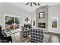 Bright living room with brick fireplace, vaulted ceiling, and sliding glass doors to the patio at 6145 E Snowdon St, Mesa, AZ 85215