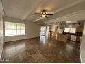Open living room with tile flooring, ceiling fan, and seamless access to the kitchen at 6842 S 42Nd Pl, Phoenix, AZ 85042