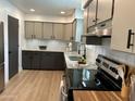 Updated kitchen featuring granite countertops, modern backsplash, stainless steel appliances, and wood flooring at 6923 E Hubbell St, Scottsdale, AZ 85257