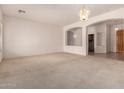 Spacious carpeted living room with archways, neutral tones, and elegant chandelier lighting at 710 W Cherrywood Dr, Chandler, AZ 85248