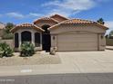 Charming single-story home with a tile roof, desert landscaping, and a two-car garage at 7724 W Topeka W Dr, Glendale, AZ 85308
