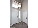 Bright foyer with a decorative light fixture, white doors, and sleek gray flooring at 8180 E Shea Blvd # 1075, Scottsdale, AZ 85260