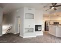 Open-concept living area with a fireplace, gray flooring, and seamless flow to the adjacent kitchen at 8180 E Shea Blvd # 1075, Scottsdale, AZ 85260