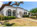 Welcoming home showcasing arched windows, manicured landscaping, and a neatly paved walkway to the front door at 8328 E Chaparral Rd, Scottsdale, AZ 85250
