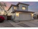 Two-story home with tan stucco, a two car garage and long driveway, at dusk at 8450 S Stephanie Ln, Tempe, AZ 85284