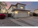 Two-story home with tan stucco, a two car garage and long driveway, at dusk at 8450 S Stephanie Ln, Tempe, AZ 85284