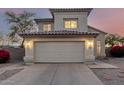 Two-story home with tan stucco, a two car garage and a driveway under an colorful evening sky at 8450 S Stephanie Ln, Tempe, AZ 85284