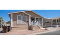 Inviting tan home with covered carport, front porch, and desert landscaping at 9431 E Coralbell Ave # 6, Mesa, AZ 85208