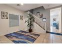 Welcoming entryway featuring neutral tile flooring, stairs to the upper level, and decorative area rug at 9948 W Chipman Rd, Tolleson, AZ 85353