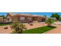 A meticulously maintained front yard features artificial turf and palm trees, adding a touch of the tropics at 10535 W San Miguel Ave, Glendale, AZ 85307