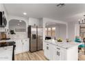 A kitchen featuring white cabinets, stainless steel appliances, an island and an open floorplan at 10625 E Bramble Ave, Mesa, AZ 85208