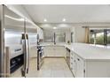 This kitchen features stainless appliances, white cabinetry and stone countertops at 11430 N 109Th St, Scottsdale, AZ 85259