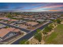 Aerial view showcasing the home's setting on a corner lot in a peaceful community with green spaces at 12516 W Mclellan Ct, Glendale, AZ 85307