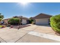 Charming home featuring a lush green lawn, desert landscaping, and a spacious driveway at 13629 W San Miguel Ave, Litchfield Park, AZ 85340