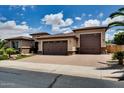 Charming single-story home featuring a three-car garage, desert landscaping, and a brick driveway at 16141 N 183Rd Dr, Surprise, AZ 85388