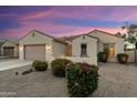 Beautiful exterior view of a home at twilight, highlighting colorful landscaping and desert accents at 16158 W Coronado Rd, Goodyear, AZ 85395