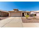 Welcoming home with desert landscaping, spacious driveway, and two-car garage, perfect for a Gathering at 1634 E Harwell Rd, Phoenix, AZ 85042