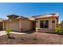 Inviting home featuring low-maintenance desert landscaping, solar panels, and a two-car garage at 1634 E Harwell Rd, Phoenix, AZ 85042