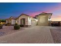 Spacious three-car garage with a brick paved driveway and desert landscaping at 18577 W Coolidge St, Goodyear, AZ 85395