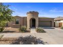 Inviting single-Gathering home with a unique turret entry, complemented by desert landscaping and a two-car garage at 23097 E Camina Buena Vis, Queen Creek, AZ 85142