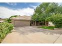 Lovely home boasts a tile roof, two-car garage, and mature desert landscaping at 2405 E Lynwood Cir, Mesa, AZ 85213