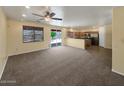 Open-concept living space with carpet, tile, kitchen, and sliding glass doors at 2521 N Franz Ln, Casa Grande, AZ 85122