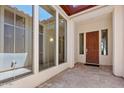 Bright patio with tiled flooring, many windows, and a stained wood front door at 30406 N 54Th St, Cave Creek, AZ 85331