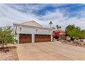 A beautiful three-car garage with a wide driveway and well maintained landscape at 3514 E Desert Willow Rd, Phoenix, AZ 85044