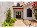 Elegant front entrance featuring double doors, desert landscaping, and exterior lighting at 3514 E Desert Willow Rd, Phoenix, AZ 85044