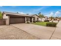 Inviting single-story home showcasing a well-kept lawn, desert landscaping, and an attached two-car garage at 3619 E Marmora St, Phoenix, AZ 85032