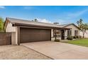 Single-story home boasting a spacious driveway leading to a two-car garage and a well-manicured front lawn at 3619 E Marmora St, Phoenix, AZ 85032